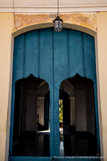 Blue wooden door with two smaller doors cut out. 