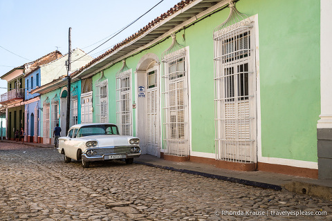 Cobblestone street and American classic car in Trinidad.