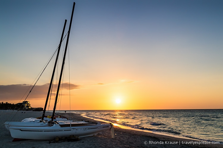 Boat on a beach at sunset.