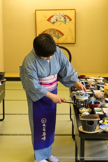 Mujer en un yukata preparando una cena tradicional japonesa en un baño termal