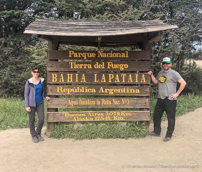 Couple standing with the End of Route 3 sign in Tierra del Fuego National Park.