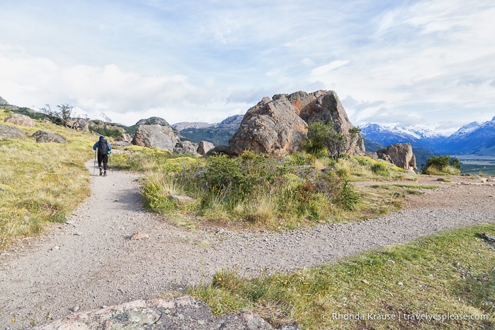 Hiker passing by a large rock at Mirador Rio de las Vueltas.