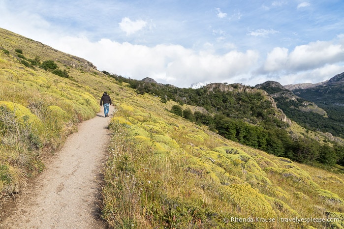 Hiker on a trail crossing a slope.