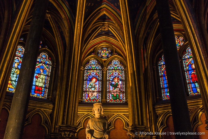 Statue and stained glass inside Sainte-Chapelle's lower chapel.