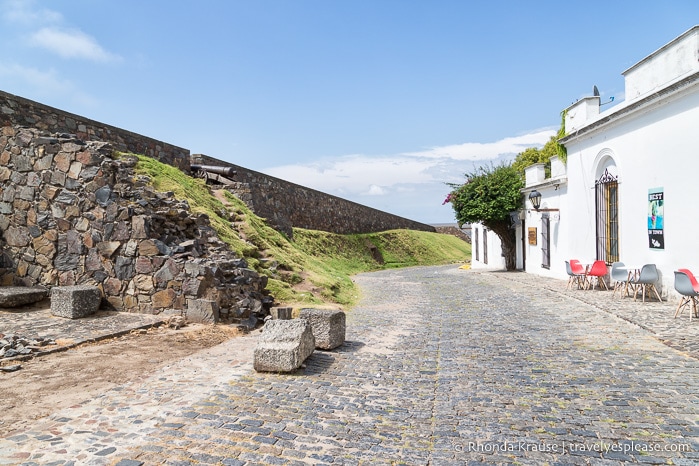 City wall beside a cobblestone street.