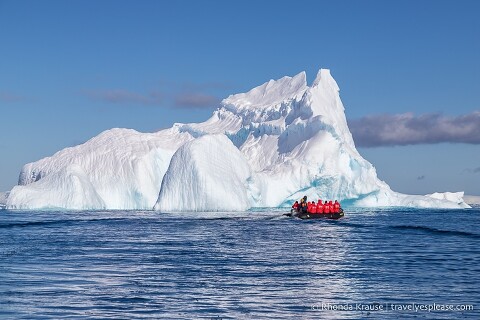 Zodiac cruising towards a big iceberg.
