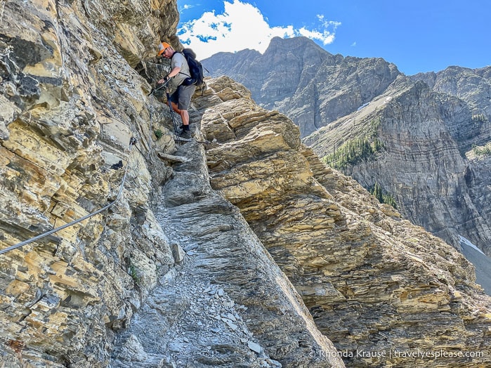 Hiker on the cable section of Crypt Lake Trail.