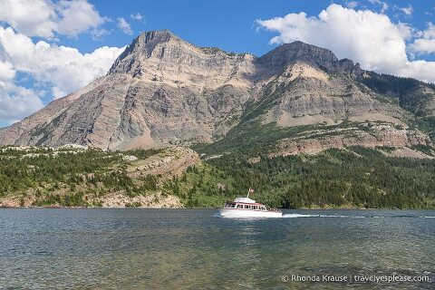Boat tour on Upper Waterton Lake passing in front of a mountain.