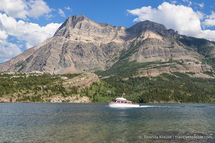 Boat tour on Upper Waterton Lake passing in front of a mountain.