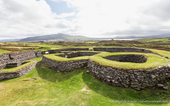 Grassy-topped stone walls of structures inside Leacanabuaile fort.