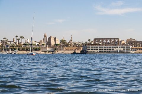 Nile River with Luxor Temple and boats in the background.