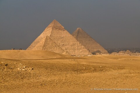 Three pyramids of Giza surrounded by sand.