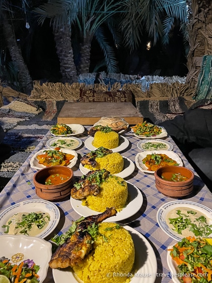 Rice and chicken dinner on a table under palm trees.