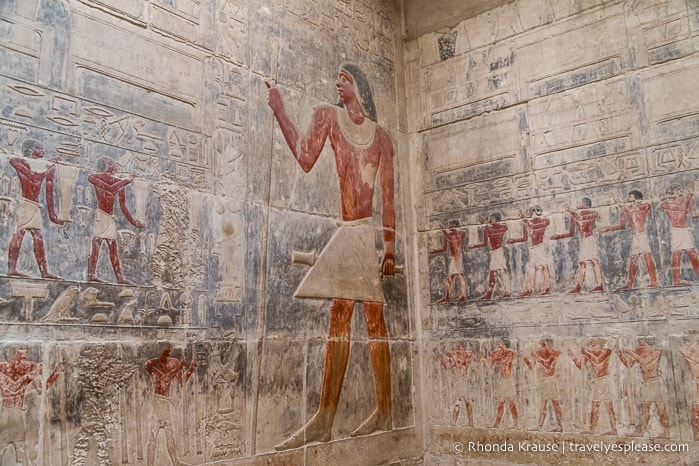 Painted reliefs of men on a tomb wall in Saqqara.