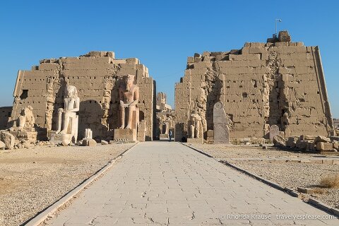 Statues in front of a ruined pylon gate at Karnak Temple.
