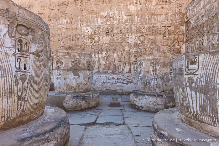 Inscriptions on a wall and ruined columns.