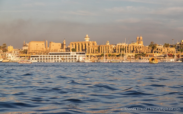 The Nile with boats and Luxor Temple in the background.