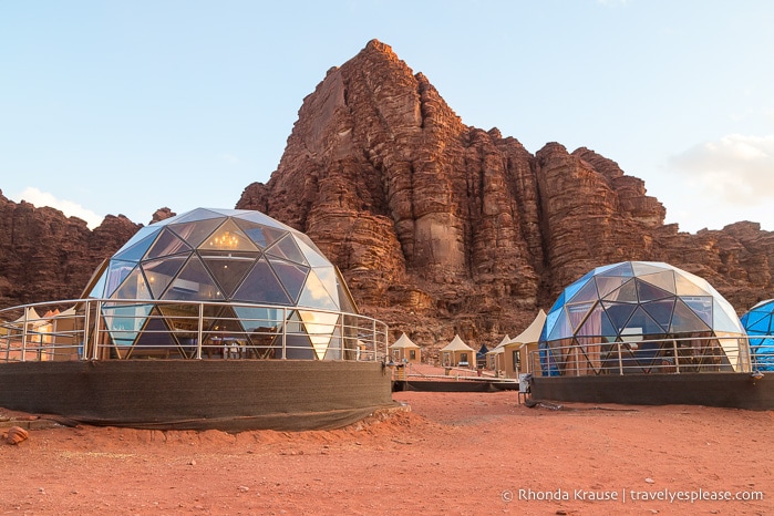 Dome tents in front of a red mountain in Wadi Rum.