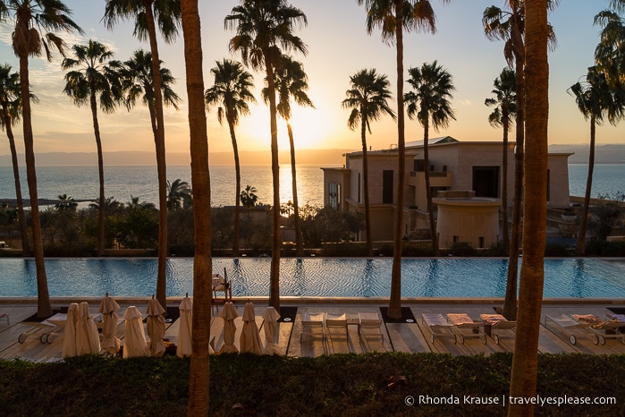 Sunset behind palm trees at a Dead Sea resort.