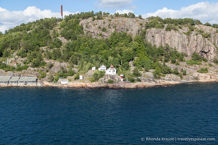 Lighthouse below a rocky cliff near Kristiansand.