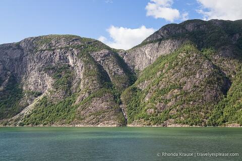 Waterfall and mountain along the shore of Hardangerfjord.