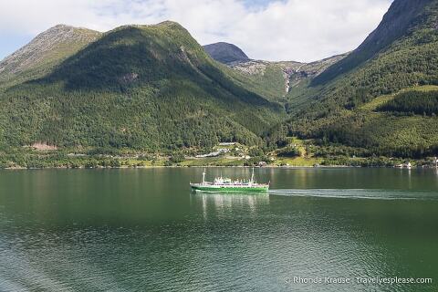 Green boat backed by mountains in Hardangerfjord, Norway.