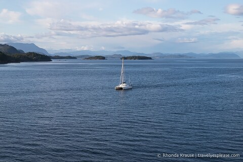 Catamaran sailing by islands in Hardangerfjord.