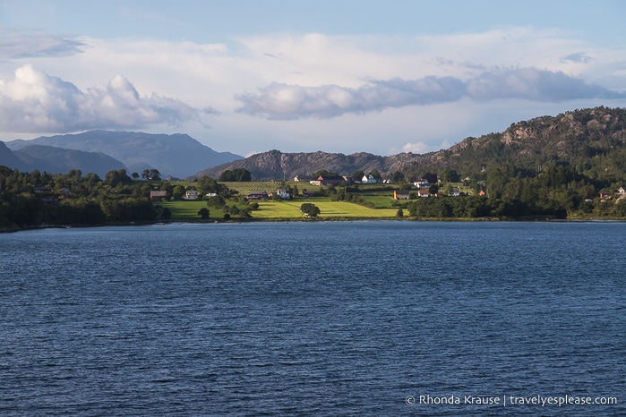 Farm fields and mountains seen while cruising Hardangerfjord.