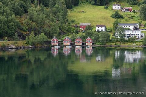 Red buildings reflecting in the water at Flam. 