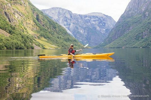 Man in a yellow kayak paddling in Naeroyfjord.