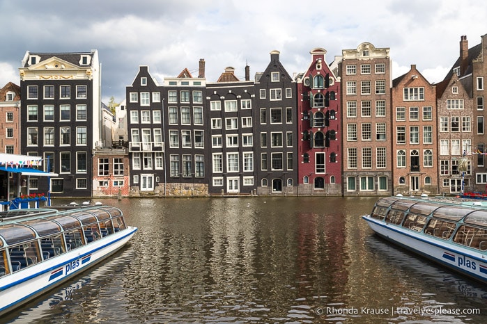 Tall narrow houses lining a canal in Amsterdam.