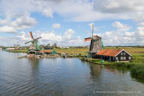 Windmills along the river at Zaanse Schans, a popular place to visit on a Netherlands trip.