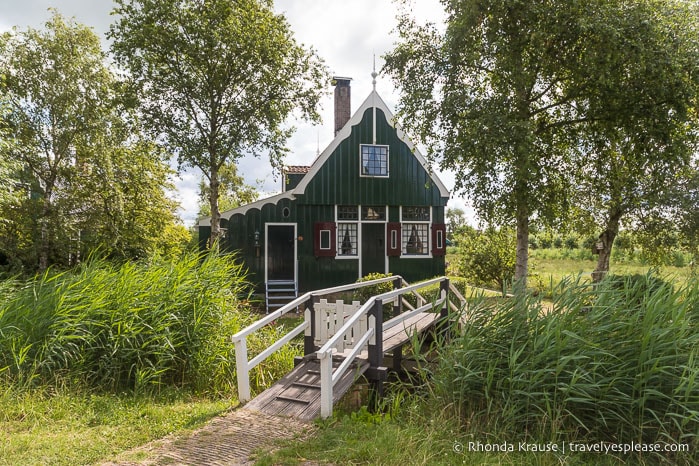 Wooden green house framed by trees at Zaanse Schans.