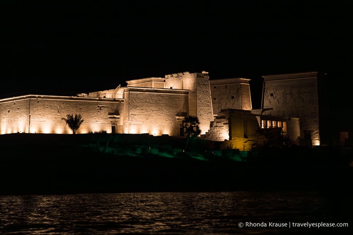View from the boat of Philae Temple illuminated at night.
