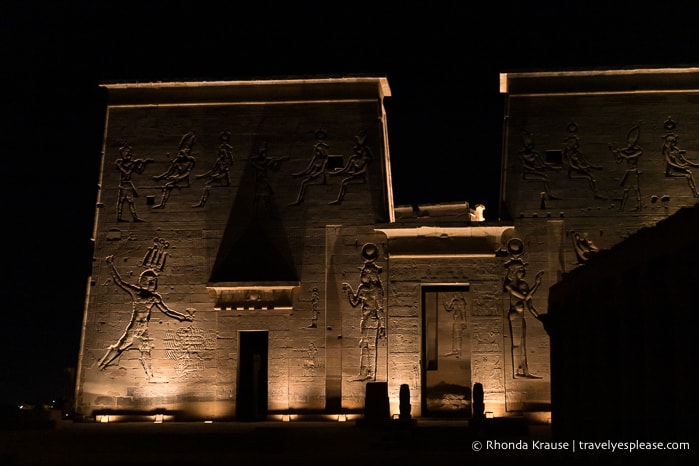 Lights shining on the first pylon of the temple.