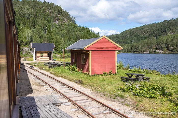 Small red building between the train tracks and the river.