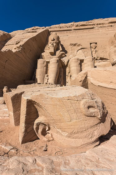 Head of the broken statue on the ground in front of the temple.