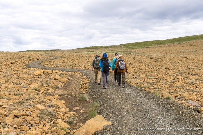 People hiking a trail through a field of rock at the start of the Green Gardens hike.