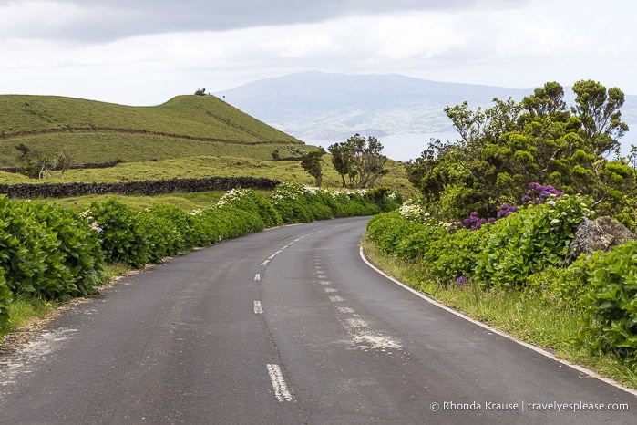 Curved road leading towards a hill. 