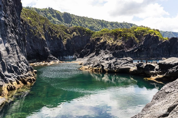Black cliffs and turquoise water at the Poça Simão Dias natural pool. 