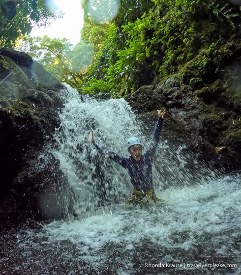 Standing under a waterfall during a canyoning tour. 
