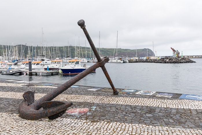 A large rusty anchor on display at the Horta marina. 